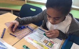 Student reading instructions and putting an electronic project together.