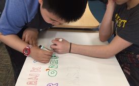  Two students making a "Thank You" poster.